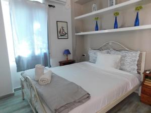 a bedroom with a white bed with towels on it at Yacht front apartment - Νο 2 in Ios Chora