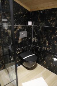 ein schwarz gefliestes Bad mit WC in einem Zimmer in der Unterkunft AYDOĞDU SUİT OTEL in Bolu