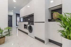 a laundry room with a washer and dryer and plants at Loft Ana Belén Home in Córdoba