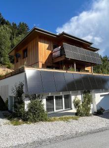 a house with solar panels on top of it at Green Mountain Retreat in Fliess