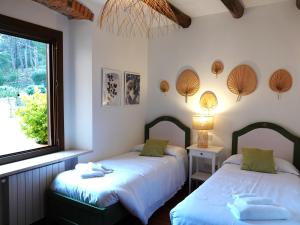 two beds in a room with a window at Agriturismo Pimpinnacolo in Porto Ercole