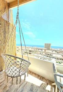 un columpio en un balcón con vistas al océano en Mirador 22, en Alicante