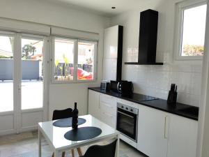 a kitchen with a table and a counter top at Entre mer et campagne in Saint-Martin-de-Seignanx +35 photos