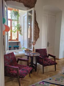 Friends Hostel في تبليسي: غرفة معيشة مع طاولة وكرسيين