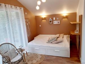 Le chalet Graines d'Amour في Grand-Champ: غرفة نوم صغيرة بها سرير ونافذة