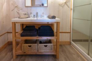 a bathroom with a sink and a counter with towels at Le Presbytère de Sévigny in Sévigny-Waleppe