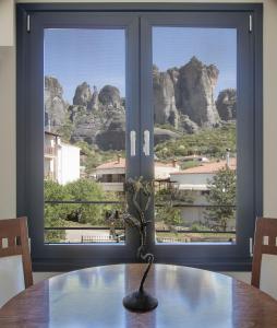 a table with a view of the mountains from a window at 1951 Suites in Kalabaka