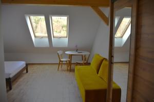 a living room with a yellow couch and a table at B&B Dom z Bali in Miłków