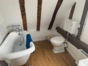 a bathroom with a toilet and a tub and a sink at Beaumont's Cottage in Cambridge