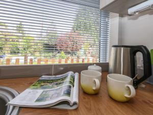 Little Timbers في رينغوود: طاولة مطبخ مع كوبين قهوة ومجلة