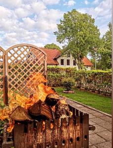 a fire in a grill in front of a house at Apartamentai Nidoje pas Virginą in Nida