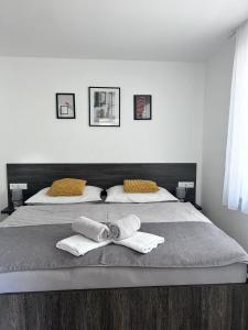 a bedroom with a bed with two towels on it at Apartmán U nás in Frymburk