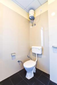 a bathroom with a toilet with a light on the wall at GMI Hotel and Benquet Jaipur in Jaipur