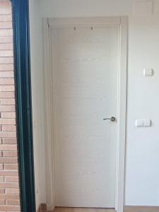 a white door in a room next to a brick wall at Arrabassada in Tarragona