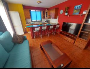 ein Wohnzimmer mit einem blauen Sofa und einer Küche in der Unterkunft Vivienda Vacacional Noni, Los Llanos de Aridane in Los Llanos de Aridane