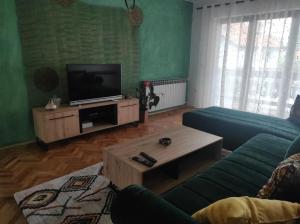 a living room with a couch and a tv at REA Home Visoko in Visoko