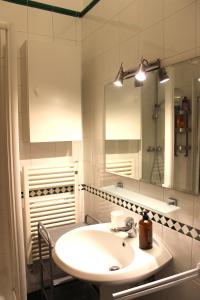 W białej łazience znajduje się umywalka i lustro. w obiekcie Navigli w Mediolanie