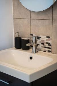 La salle de bains est pourvue d'un lavabo blanc et d'un miroir au-dessus. dans l'établissement Studio vue sur les Salins Roses, à Arles