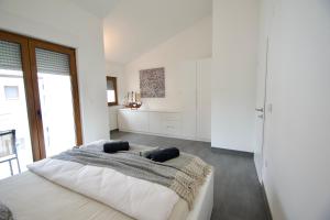 ein Schlafzimmer mit einem großen Bett mit weißen Wänden in der Unterkunft Apartmani Rajković in Matulji