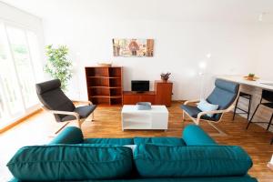 ein Wohnzimmer mit einem Sofa und 2 Stühlen in der Unterkunft Apartamento en Parque Central in Tarragona