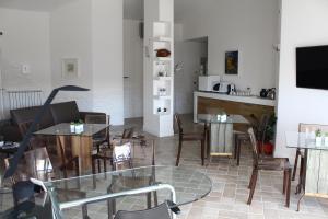 Una sala de estar con mesas y sillas y una cocina. en Attico Luxury B&B, en Santa Maria Capua Vetere