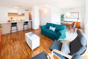 ein Wohnzimmer mit einem blauen Sofa und einer Küche in der Unterkunft Apartamento en Parque Central in Tarragona