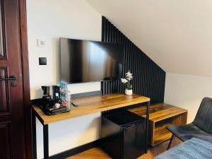 プジャスニシュにあるホテル ミレニアムのデスク、壁掛けテレビが備わる客室です。