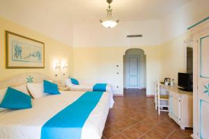 a hotel room with two beds and a television at Hotel Villa Campana in Cala Liberotto