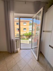 an open door to a balcony with a view of a building at Appartamento La Mola in Varazze