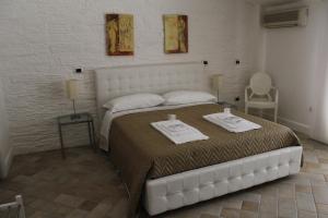 1 dormitorio con 1 cama blanca grande y toallas. en Attico Luxury B&B, en Santa Maria Capua Vetere