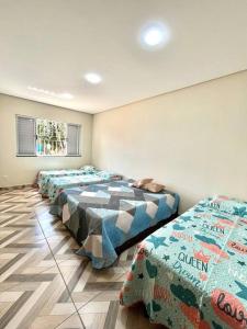 a room with four beds in a row in it at Casa Alfenas Represa Furnas c/ Piscina Aquecida 12 pessoas in Alfenas
