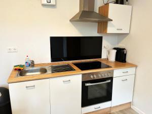 een keuken met een fornuis en een wastafel bij GÜNSTIGE PREMIUM UNTERKUNFT in MÖNCHENGLADBACH in Mönchengladbach