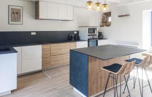 a kitchen with a counter and stools in it at 4 Bedroom Amazing Home In Plouézec in Plouézec