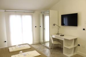 Zimmer mit einem Schreibtisch und einem TV an der Wand in der Unterkunft Attico Luxury B&B in Santa Maria Capua Vetere