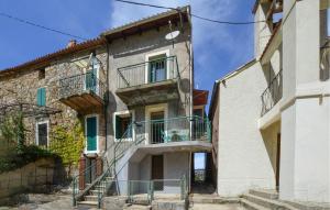 ein altes Steingebäude mit einer Treppe und einem Balkon in der Unterkunft Beautiful Home In Marignana With House A Mountain View in Marignana