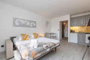1 Schlafzimmer mit einem großen Bett und einer Küche in der Unterkunft Beau studio avec terrasse ensoleillée - Proche mer in Cagnes-sur-Mer