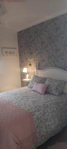 een slaapkamer met een bed met een roze kussen erop bij Casa Rural Los Jilgueros in Pujerra
