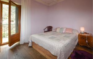 Schlafzimmer mit einem Bett, einem Tisch und einem Fenster in der Unterkunft Beautiful Home In Marignana With House A Mountain View in Marignana