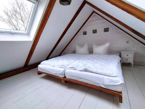 um quarto com uma cama branca num sótão em Fährhaus Wittower Fähre em Wiek auf Rügen