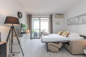 ein Schlafzimmer mit einem Bett und einem TV in der Unterkunft Beau studio avec terrasse ensoleillée - Proche mer in Cagnes-sur-Mer