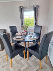 a dining room with a table and four chairs at Beach Resort Nieuwvliet Bad - NV 37 in Nieuwvliet +6 photos