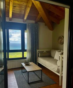 a living room with a couch and a large window at Hotel Gerra Mayor in San Vicente de la Barquera