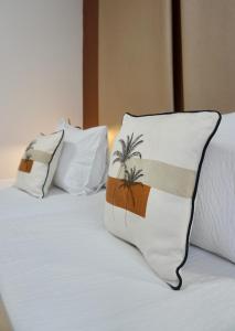 two pillows with palm trees on a bed at Hotel Gerra Mayor in San Vicente de la Barquera