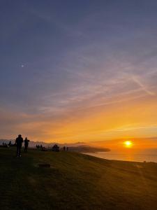 a group of people standing on a hill watching the sunset at Hotel Gerra Mayor in San Vicente de la Barquera