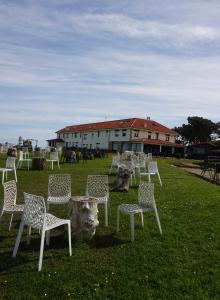 a group of chairs sitting in the grass in front of a building at Hotel Gerra Mayor in San Vicente de la Barquera