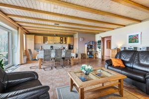 a living room with leather furniture and a table at Fördehof Petersen - Sonderburg in Westerholz