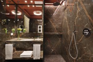 uma casa de banho com um chuveiro e um lavatório. em Villa Cortine Palace Hotel em Sirmione
