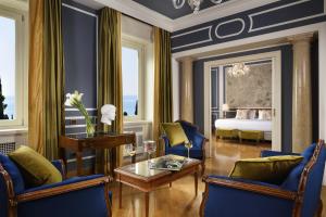 un soggiorno con sedie blu e un letto di Villa Cortine Palace Hotel a Sirmione