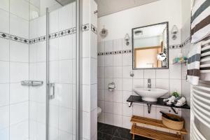 a white bathroom with a sink and a shower at Fördehof Petersen - Sonderburg in Westerholz