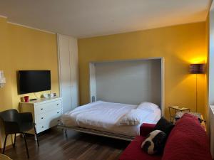 a bedroom with a bed with a dog laying on a couch at Casa Anna Giulia in Castione della Presolana
